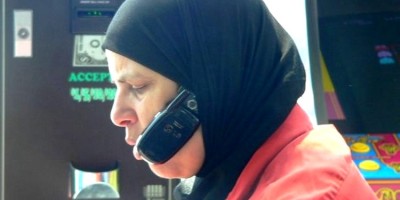 Femme musulmane avec smartphone accroché sous le foulard